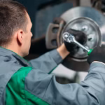 car-lifted-automobile-service-fixing-worker-repairs-wheel