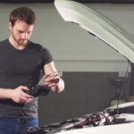 car-mechanic-using-electrical-tool-testing-car-system-garage-repair