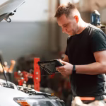 man using a tablet whiole repairing a car